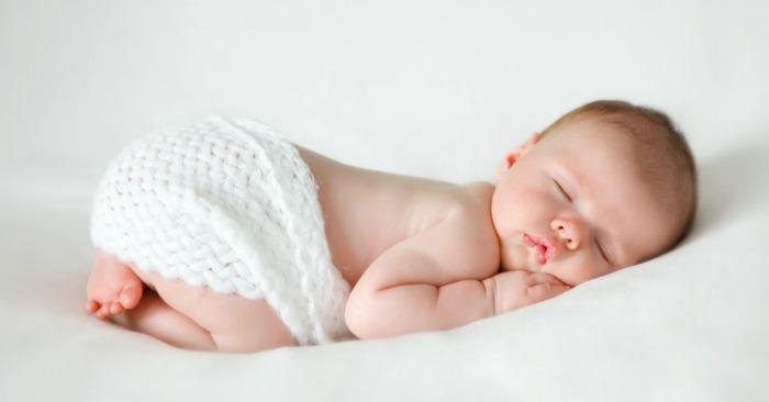 Baby sleeping on white sheets