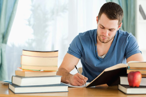 Man reading and writing a book