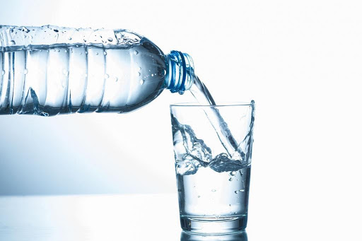 Water poured from plastic bottle to cup