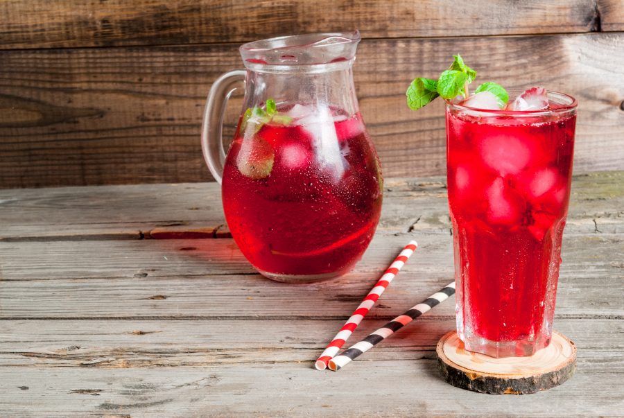 A cup and jug od red tea with ice